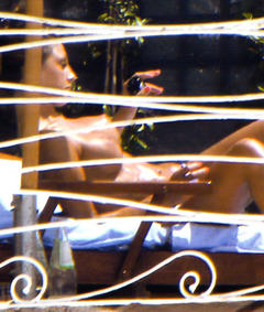 Italian actress and singer Anna Tatangelo sunbathing topless on a beach paparazzi photo
