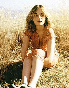 Zooey Deschanel sitting in nature