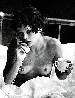 Milla Jovovich topless on a bed