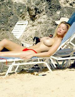 Alicia Douvall sunbathing topless on a beach