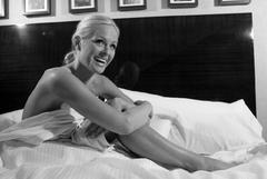 Katie Lohmann naked but covered in a bed