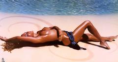 Randi Ingerman lying nude on a sand