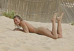 Nell McAndrew lying naked on a beach