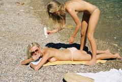 Charlie Newman and Julia Almendra sunbathing topless on a beach