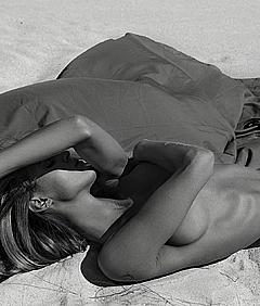 Joy Corrigan lying nude in a desert