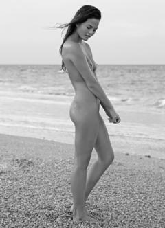 Chrissy Teigen naked on a beach black-&-white image