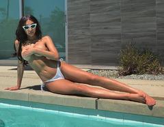 Chantel Jeffries lying topless poolside cover her breasts