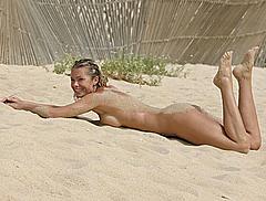 Nell McAndrew lying naked on a beach in Barbados