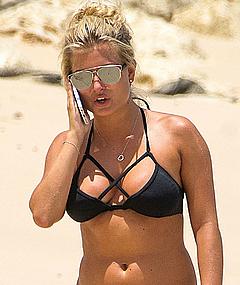 Zara Holland in black bikini on a beach
