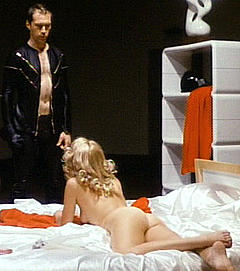 Simone Griffeth lying nude on a bed in Death Race 2000