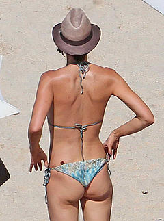 Tamara Mellon in bikini and hat on a beach