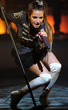 Brenda Asnicar performs on a stage
