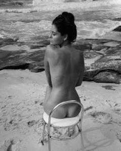 Maga Ripper sitting naked on a beach