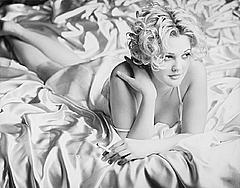 Blonde actress Drew Barrymore lying on a bed