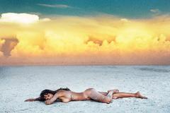 Erica Candice lying naked on a sand