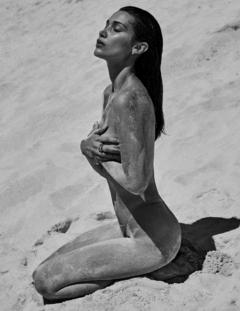 Bella Hadid topless on a beach cover her breasts