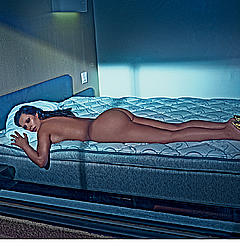 Kim Kardashian lying fully nude on a bed