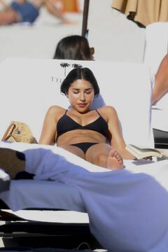 Chantel Jeffries sunbathing in black bikini on the beach in Miami Beach - December 20, 2025