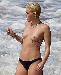 Miley Cyrus topless on a beach