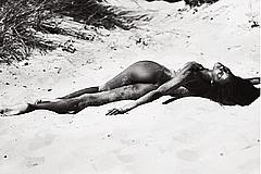 Ebonee Davis lying naked on a beach