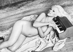 Blonde singer Christina Aguilera lying naked cover her breasts