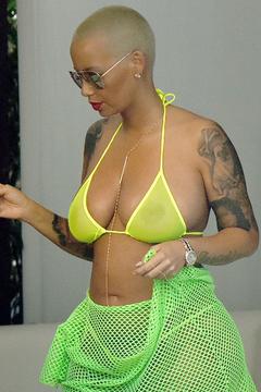 Amber Rose in yellow see through bikini top by the pool In Miami Beach