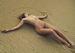 Lauren Bonner lying fully nude on a sand