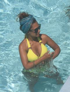 Preeya Kalidas in yellow bikini in a pool