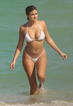 French model Tao Wickrath in thong white bikini in the ocean as she shows off all of her curves in Miami Beach on a hot day