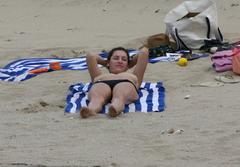 Kelly Brook sunbathing topless on a beach