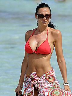 Nicole Minetti in red bikini on a beach