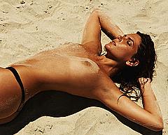 Mariana Goldfarb sunbathing topless on a beach