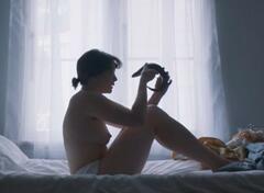 Edith Poor topless on a bed at Daniel