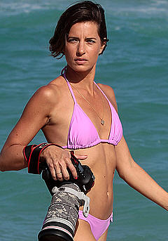 Logan Fazio in a purple bikini with camera on Miami beach