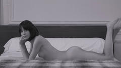 Stacy Martin lying naked on a bed