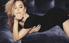 Amber Heard in short black dress on a sofa