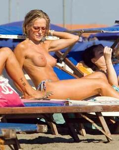 Brigitta Boccoli sunabthing topless on a beach