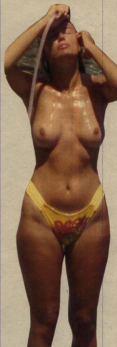 Licia Colo wet and topless on a beach