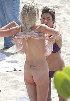 Laeticia Hallyday nude for a photoshoot on a beach