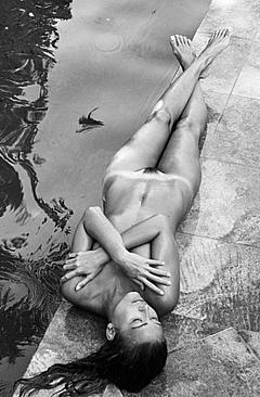 Marisa Papen lying naked poolside cover her tits