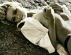 Martina Stella lying topless cover her tits