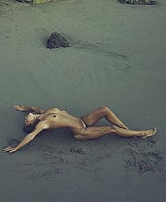 Marisa Papen lying fully nude on a beach