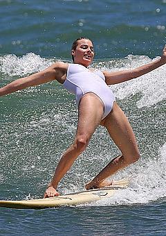 Margot Robbie surfing in white swimsuit