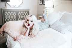 Dove Cameron lying on a bed